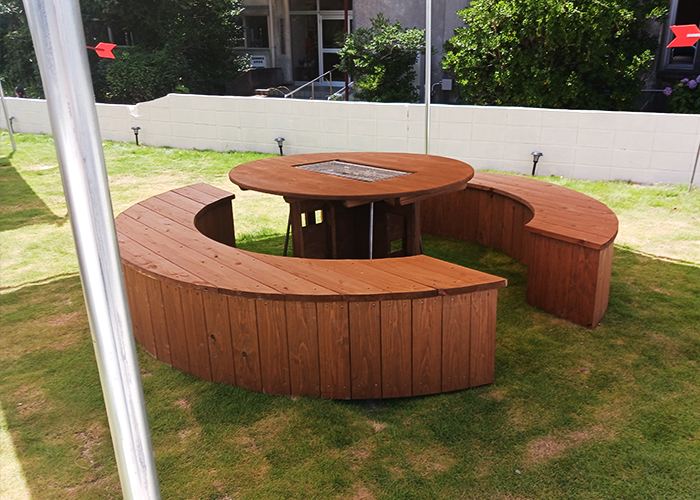 敷地裏の芝生広場では最大50人までのバーベキューが可能。木製テーブルや日よけがあり、開放的でおしゃれな空間